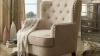 Tufted wingback chair with brass studs and wooden legs.